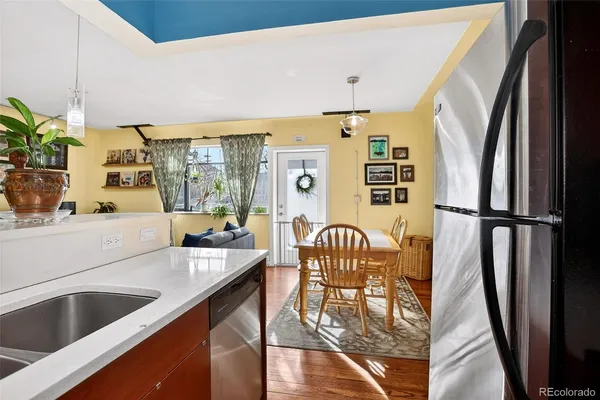 a kitchen with stainless steel appliances granite countertop a refrigerator a sink a stove and white cabinets