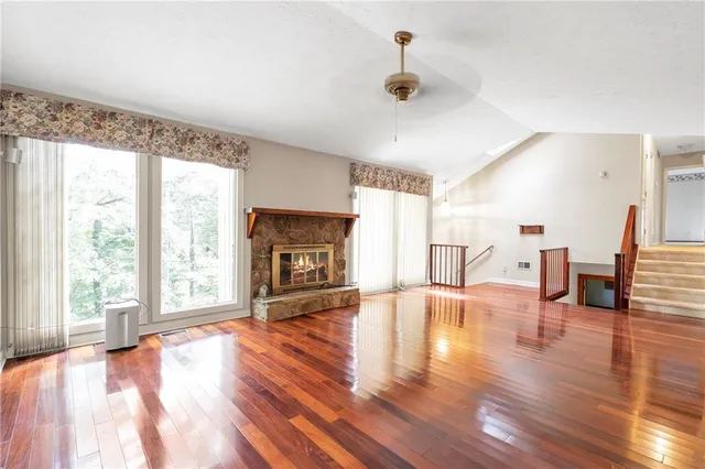 a view of empty room with wooden floor and fireplace