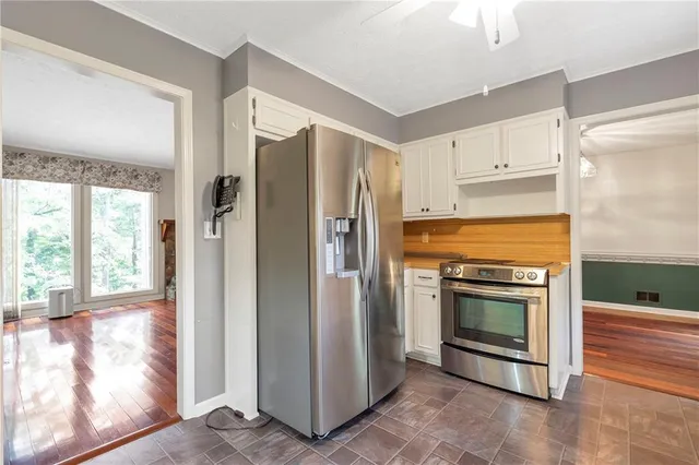 a kitchen with stainless steel appliances granite countertop a refrigerator a stove and a sink