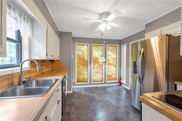 a kitchen with stainless steel appliances granite countertop a refrigerator a sink and a stove