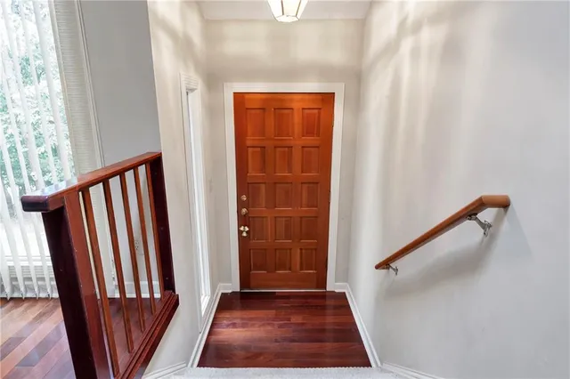 a view of a hallway with wooden floor and stairs