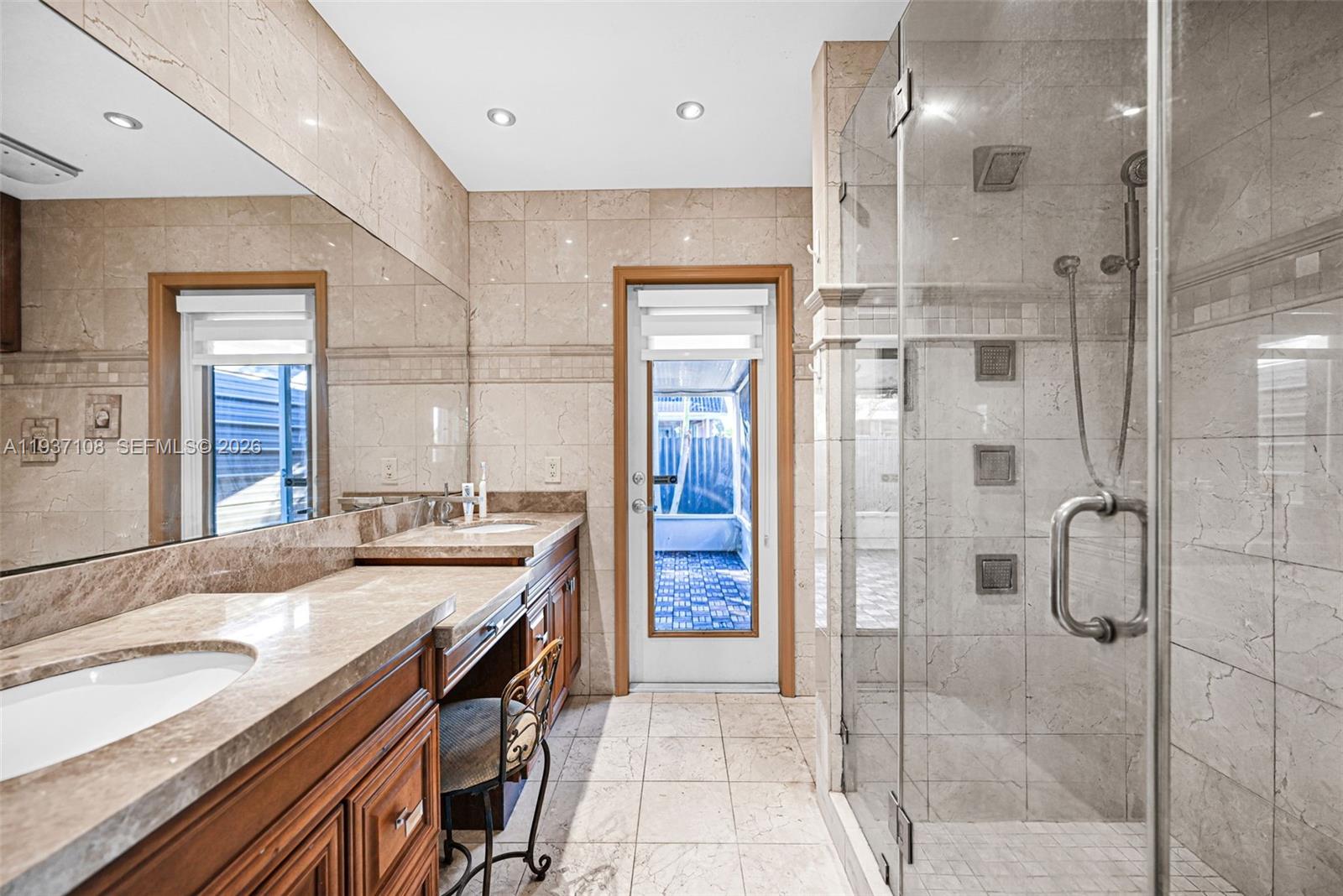 17020 Southwest 149th Avenue Miami, FL 33187 - Photo 37 of 68 a bathroom with a granite countertop sink mirror and shower