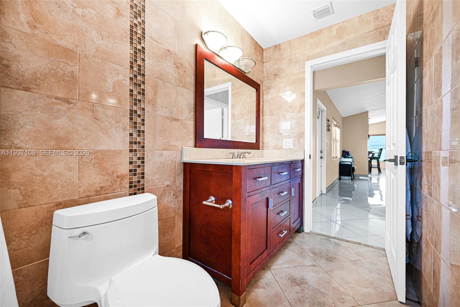 17020 Southwest 149th Avenue Miami, FL 33187 - Photo 44 of 68 a bathroom with a toilet a sink and a mirror