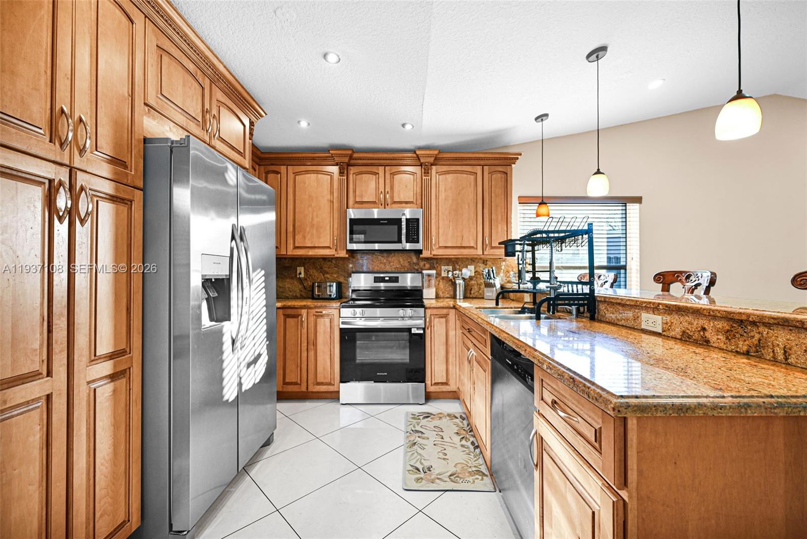 17020 Southwest 149th Avenue Miami, FL 33187 - Photo 53 of 68 a kitchen with stainless steel appliances granite countertop a refrigerator a sink and a stove