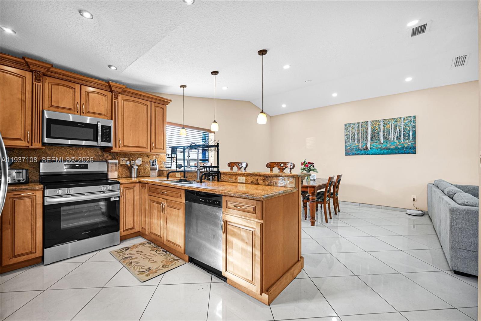 17020 Southwest 149th Avenue Miami, FL 33187 - Photo 54 of 68 a kitchen with stainless steel appliances granite countertop a stove top oven a sink a counter top space cabinets and a view of living room