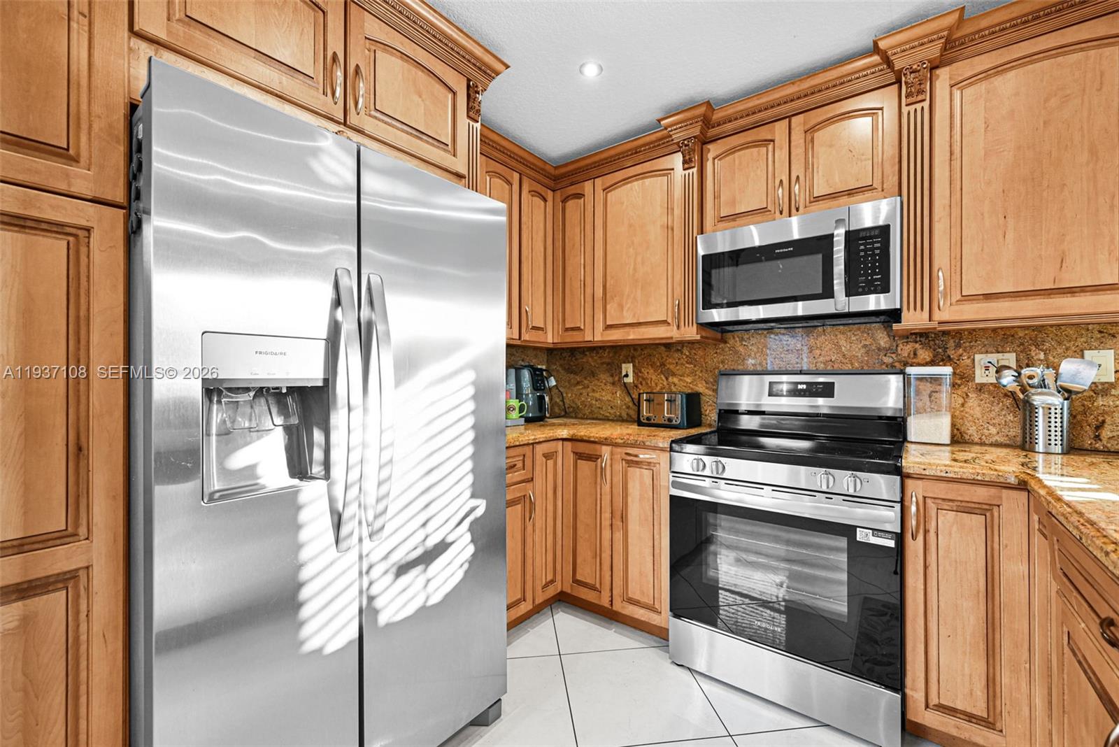 17020 Southwest 149th Avenue Miami, FL 33187 - Photo 55 of 68 a kitchen with stainless steel appliances granite countertop a refrigerator and a stove top oven