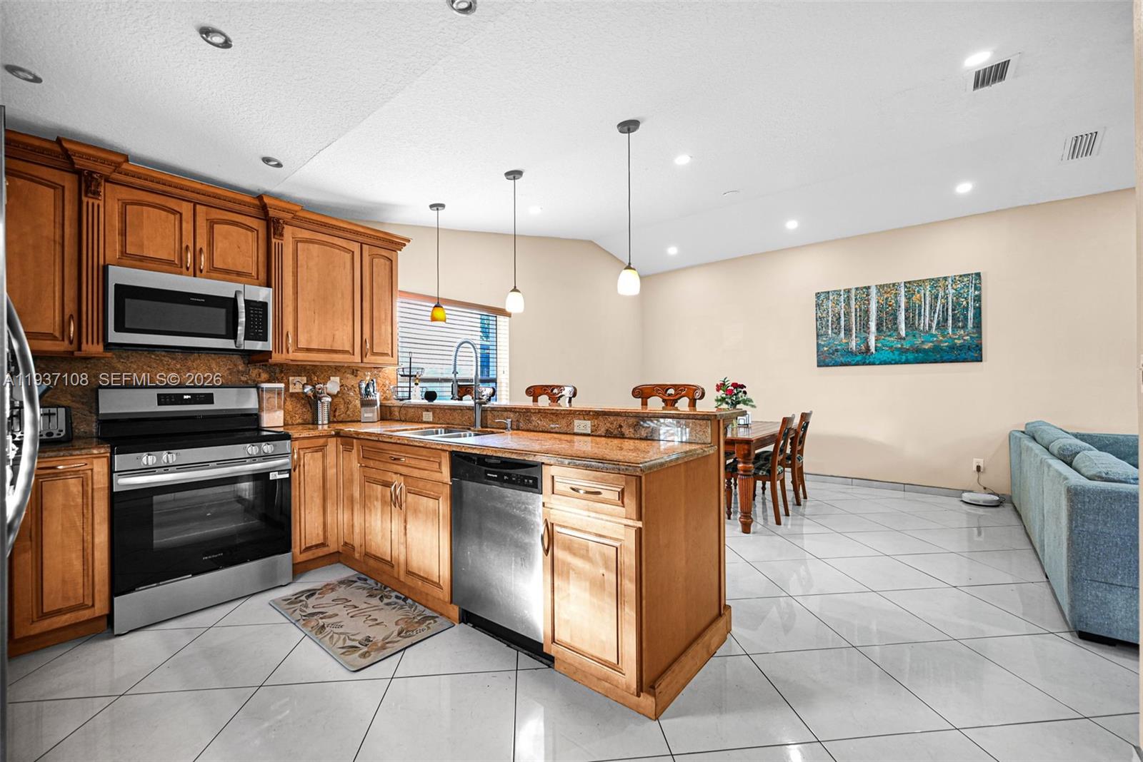 17020 Southwest 149th Avenue Miami, FL 33187 - Photo 57 of 68 a kitchen with stainless steel appliances granite countertop a stove top oven a sink a dining table and chairs