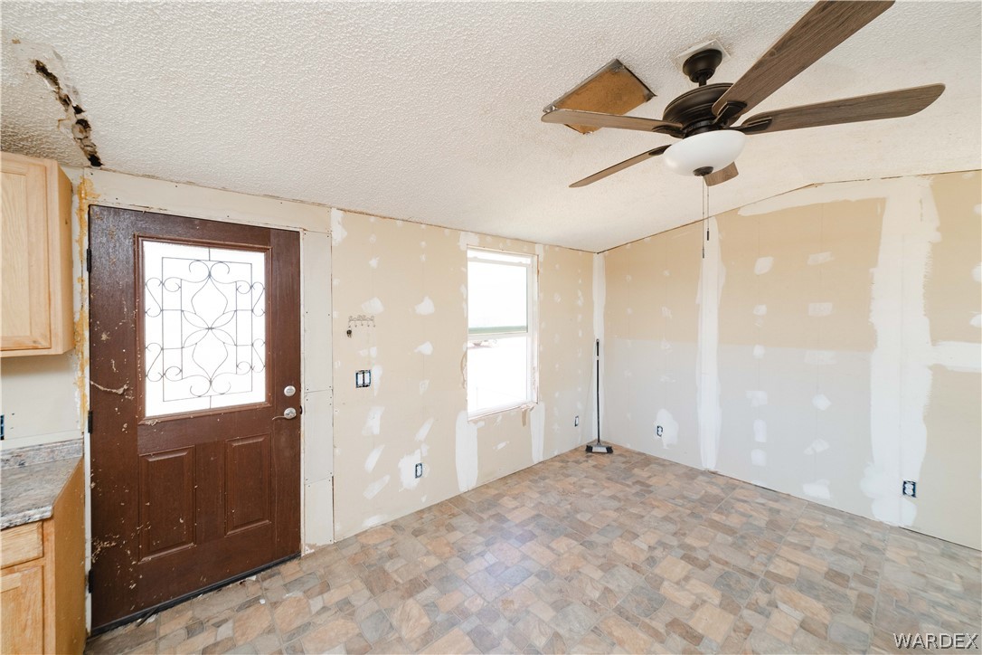 16435 South Wyatt Earp Road Yucca, AZ 86438 - Photo 4 of 57 Room featuring a ceiling fan with light fixture, window, and patterned tile flooring
