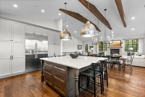 a kitchen with stainless steel appliances kitchen island granite countertop a sink cabinets and wooden floor