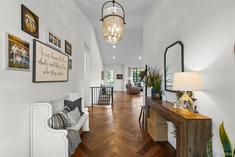 a view of a room with wooden floor chandelier and windows
