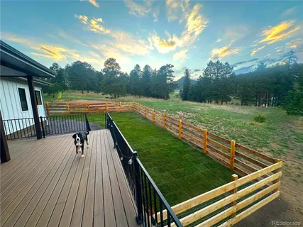 a view of a roof deck with table and chairs with wooden floor and fence