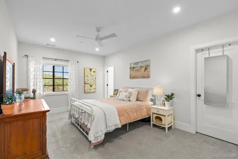 a large bedroom with a bed and a large mirror on the dresser