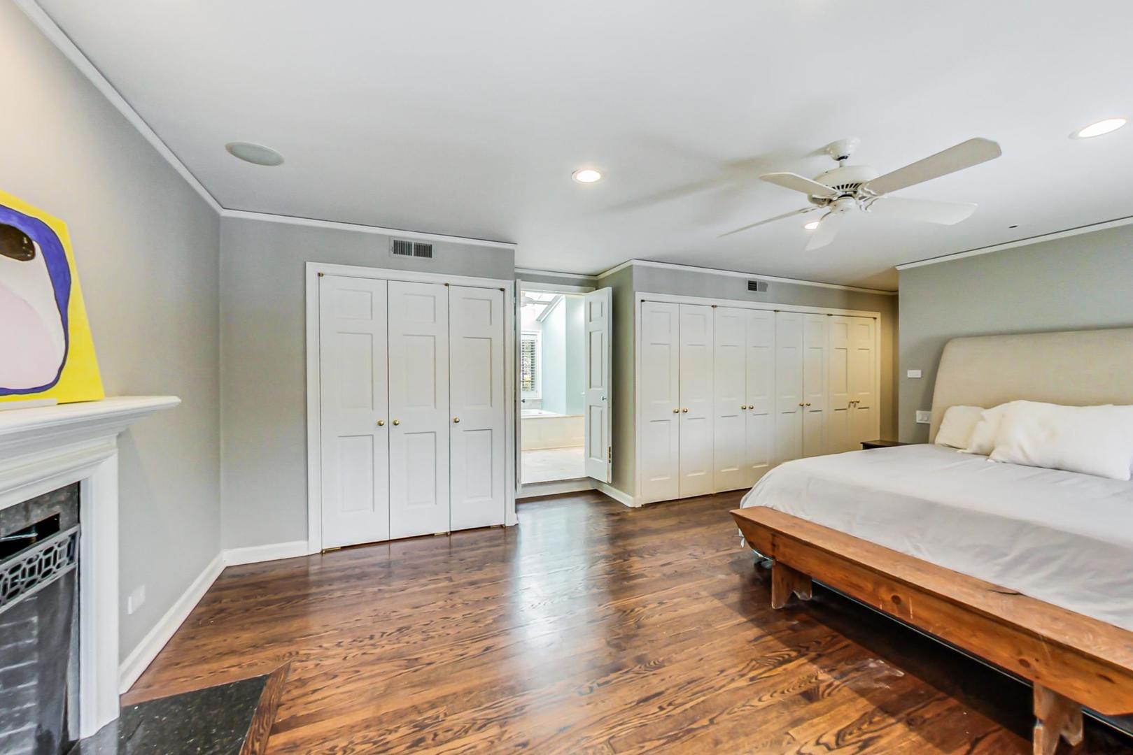 875 Fairview Road Highland Park, IL 60035 - Photo 18 of 32 a spacious bedroom with a bed and a chandelier