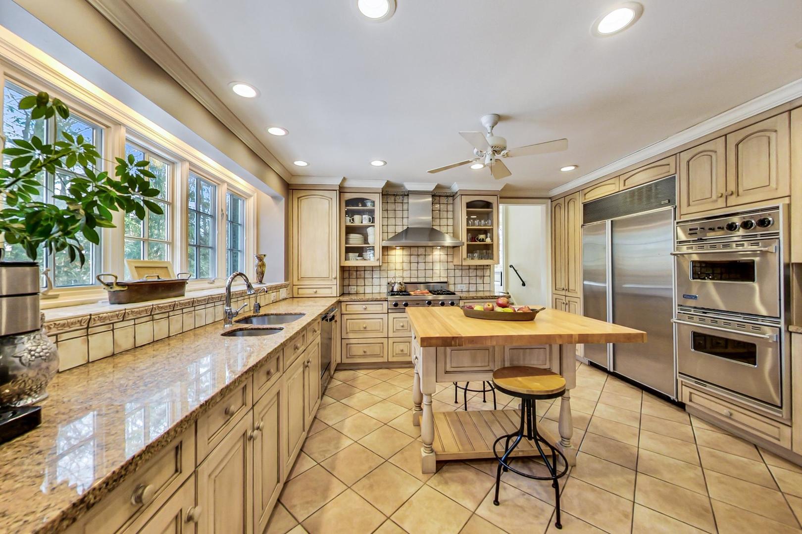 875 Fairview Road Highland Park, IL 60035 - Photo 8 of 32 a kitchen with stainless steel appliances granite countertop a sink a stove and a refrigerator