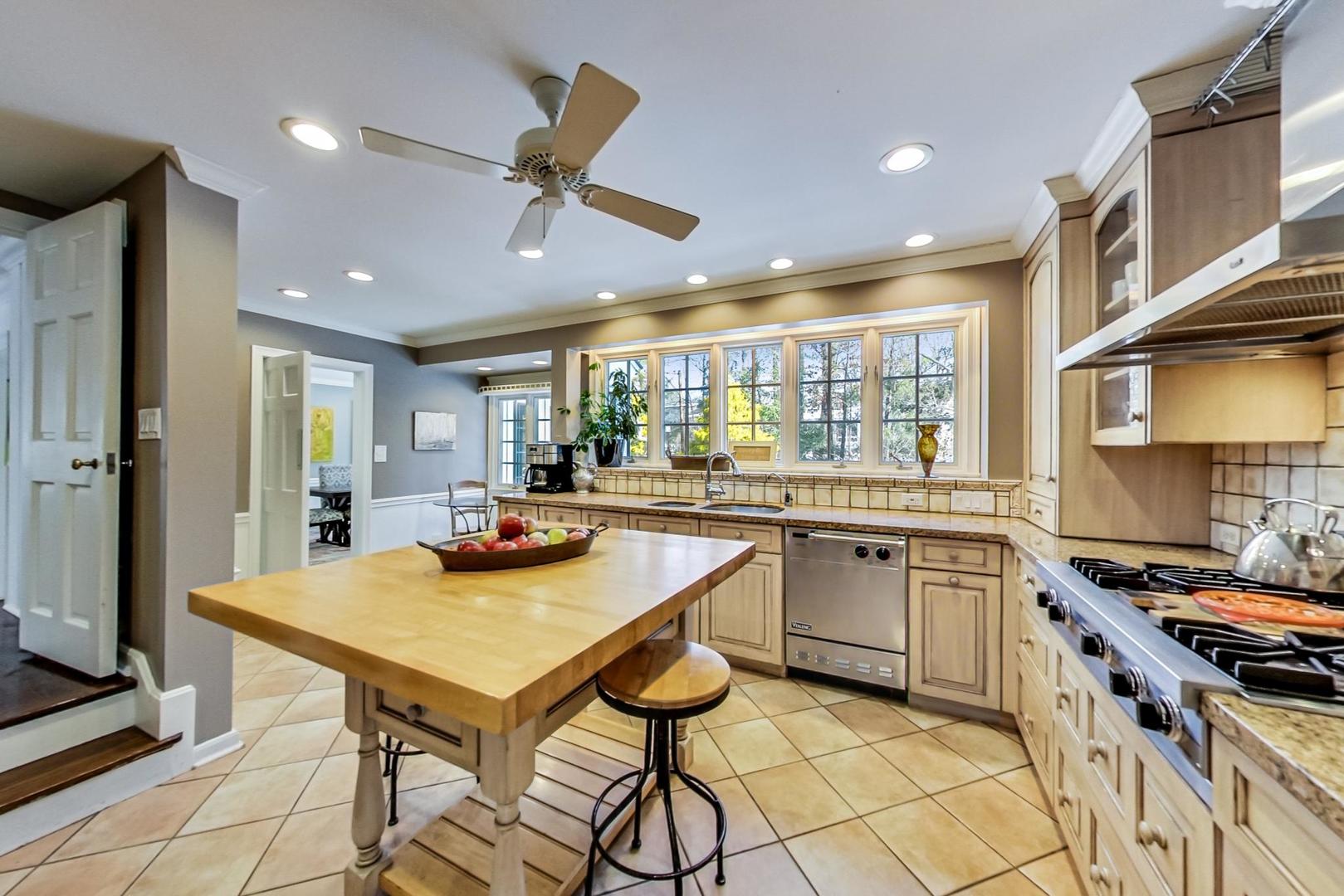 875 Fairview Road Highland Park, IL 60035 - Photo 10 of 32 a kitchen with stainless steel appliances kitchen island granite countertop a table and chairs in it