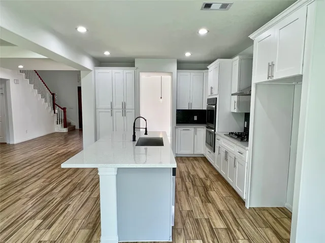 a kitchen with stainless steel appliances a refrigerator sink and cabinets