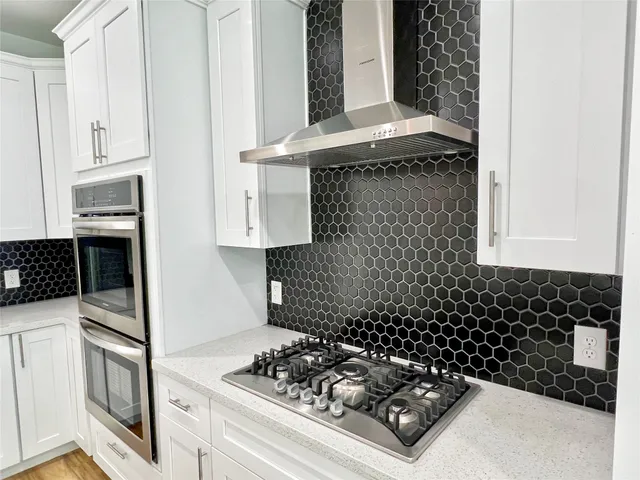 a kitchen with white cabinets and appliances