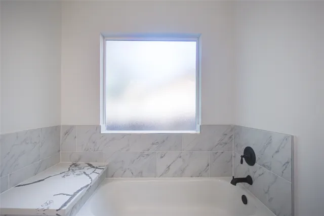 a bathroom with a bathtub and a window