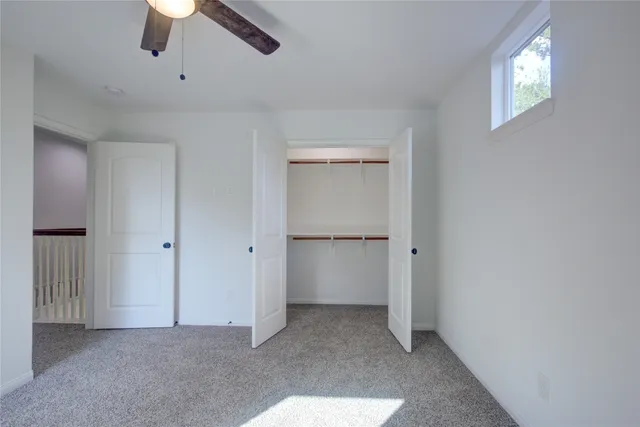 a view of an empty room and a ceiling fan