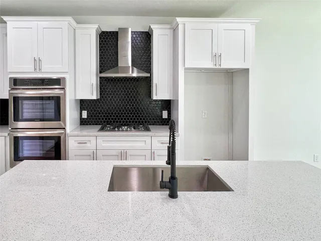 a kitchen with kitchen island a counter top stainless steel appliances and cabinets