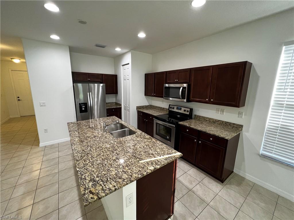 5542 Useppa Drive Ave Maria, FL 34142 - Photo 5 of 15 a kitchen with stainless steel appliances granite countertop a refrigerator and a stove top oven