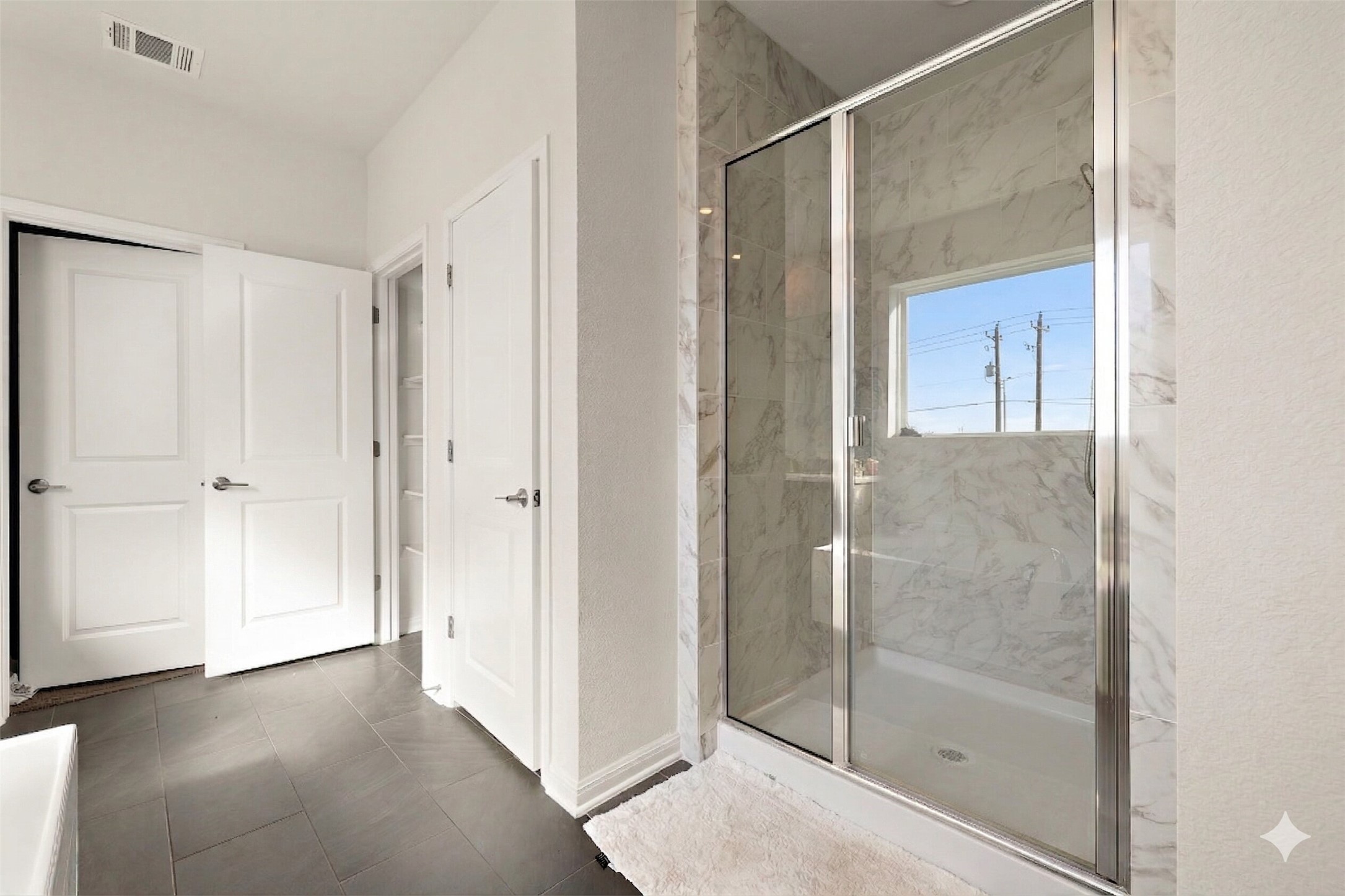 604 Spindrift Lane Leander, TX 78641 - Photo 6 of 32 Bathroom with a marble finish shower and dark tile patterned flooring