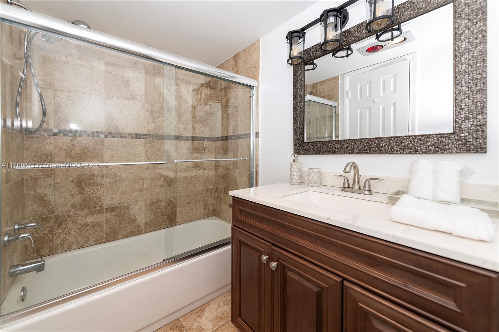 2750 Northeast 183rd Street, Unit 1207 Aventura, FL 33160 - Photo 12 of 21 a bathroom with a granite countertop sink a mirror and shower