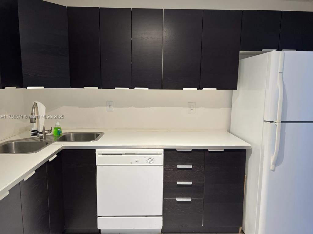2750 Northeast 183rd Street, Unit 1207 Aventura, FL 33160 - Photo 3 of 21 a kitchen with a sink and a refrigerator