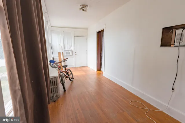 a view of a hallway with wooden floor and furniture