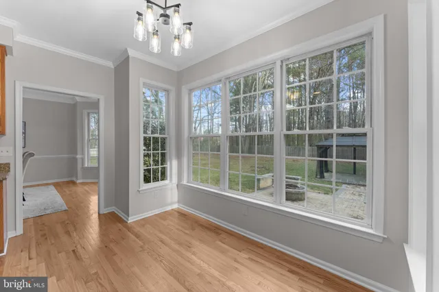 a view of a hallway with wooden floor and windows