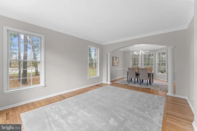 a kitchen with stainless steel appliances kitchen island granite countertop a refrigerator a stove a sink a dining table and chairs with wooden floor