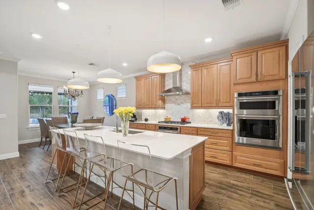 a kitchen with stainless steel appliances a table and chairs in it