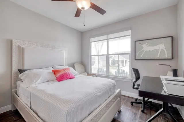 a bedroom with a bed a computer on a desk and chair