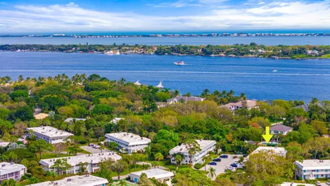 a sign of golf club on a wall under a tree
