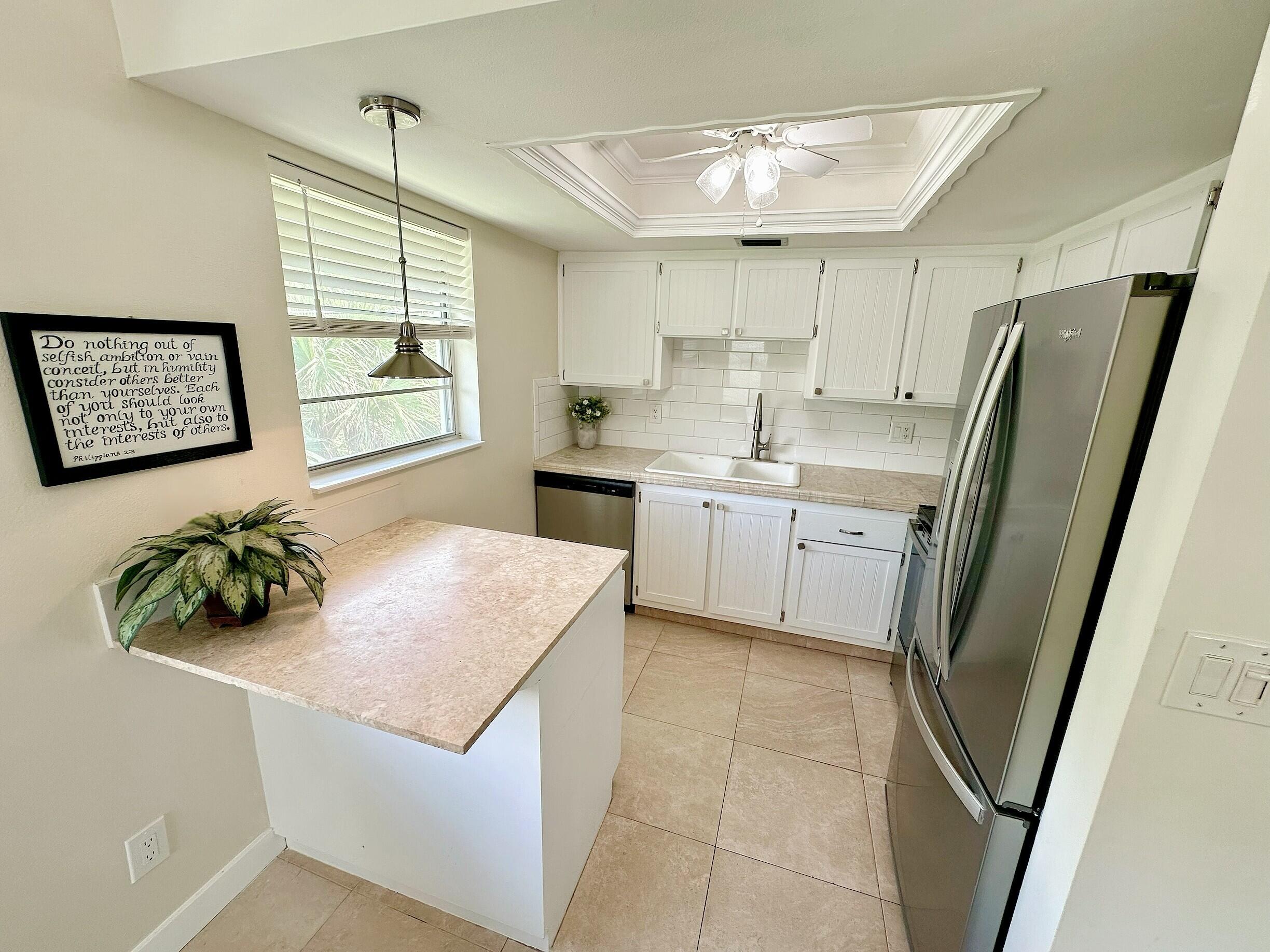 2929 Southeast Ocean Boulevard, Unit 10510 Stuart, FL 34996 - Photo 6 of 37 a kitchen with stainless steel appliances a refrigerator sink and wooden floor