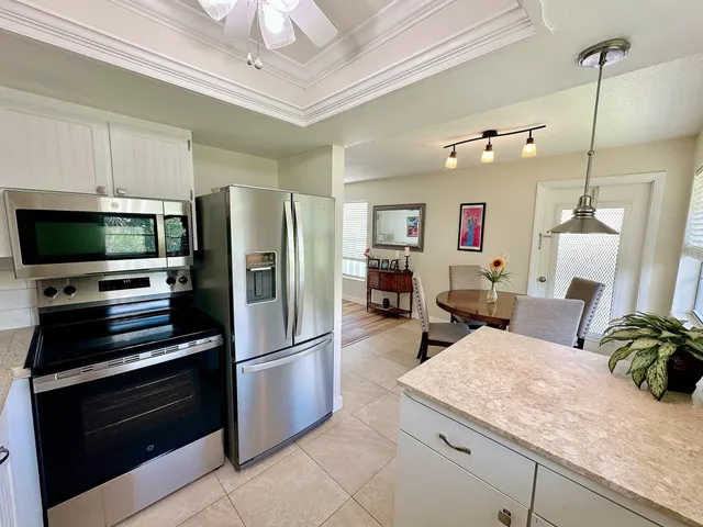a kitchen with stainless steel appliances kitchen island granite countertop a refrigerator and a stove top oven