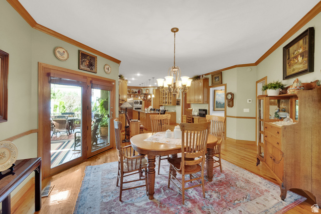 7740 Keswick Road Sandy, UT 84093 - Photo 21 of 74 Dining area with wood-finish flooring, a contemporary chandelier, and French doors leading to an outdoor space