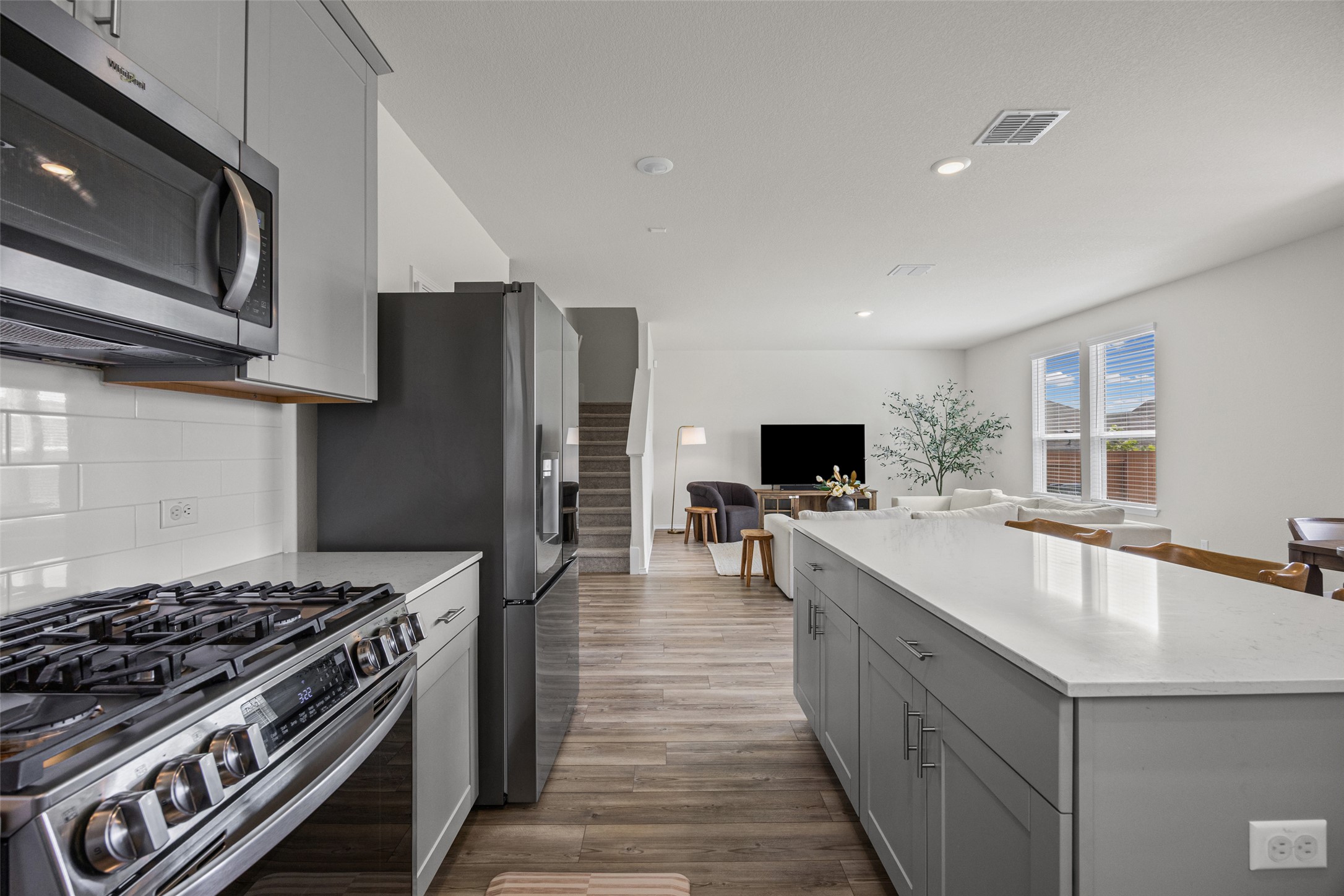208 Orange Road Buda, TX 78610 - Photo 6 of 31 A contemporary open-concept layout showcases a kitchen with sleek appliances seamlessly flowing into the living area.