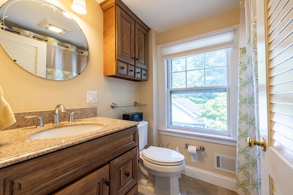9 Parkman Road Reading, MA 01867 - Photo 19 of 34 a bathroom with a granite countertop sink mirror vanity and toilet