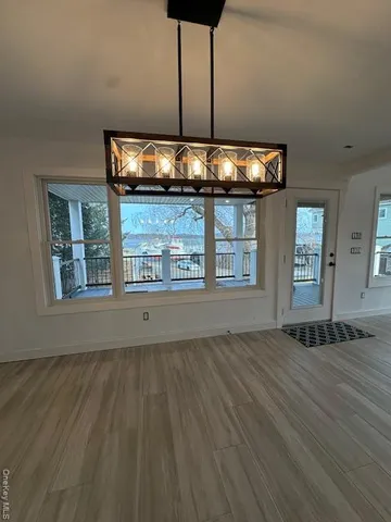 an empty room with window and wooden floor