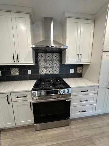 a stove top oven sitting inside of a kitchen
