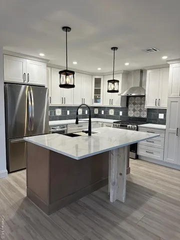 a kitchen with stainless steel appliances granite countertop a sink a stove and a refrigerator