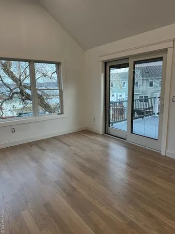 a view of a big room with wooden floor and windows