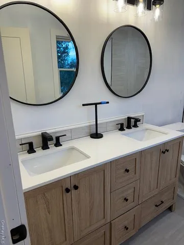 a bathroom with a double vanity sink and a mirror