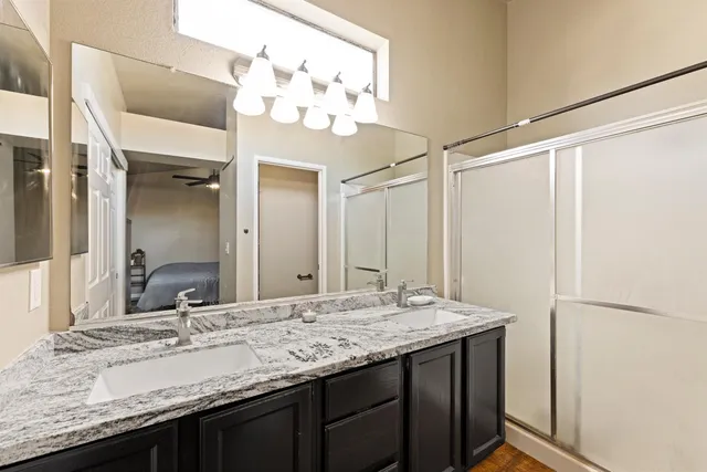 a bathroom with a granite countertop sink and a mirror