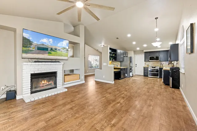 a open kitchen view with fireplace a stove and a chandelier