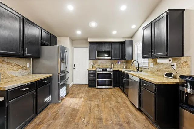 a kitchen with granite countertop stainless steel appliances and wooden cabinets