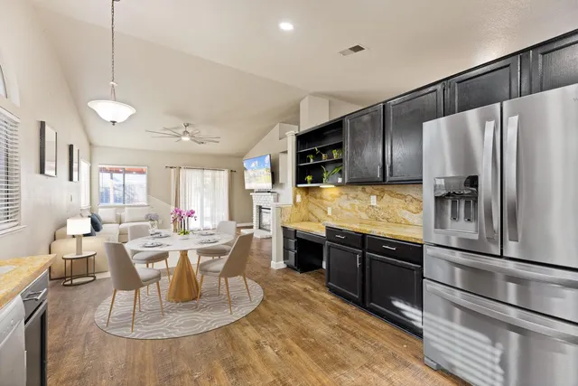 a kitchen with stainless steel appliances granite countertop a sink refrigerator and cabinets