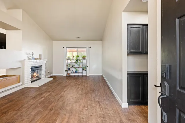 a view of empty room with wooden floor and fireplace
