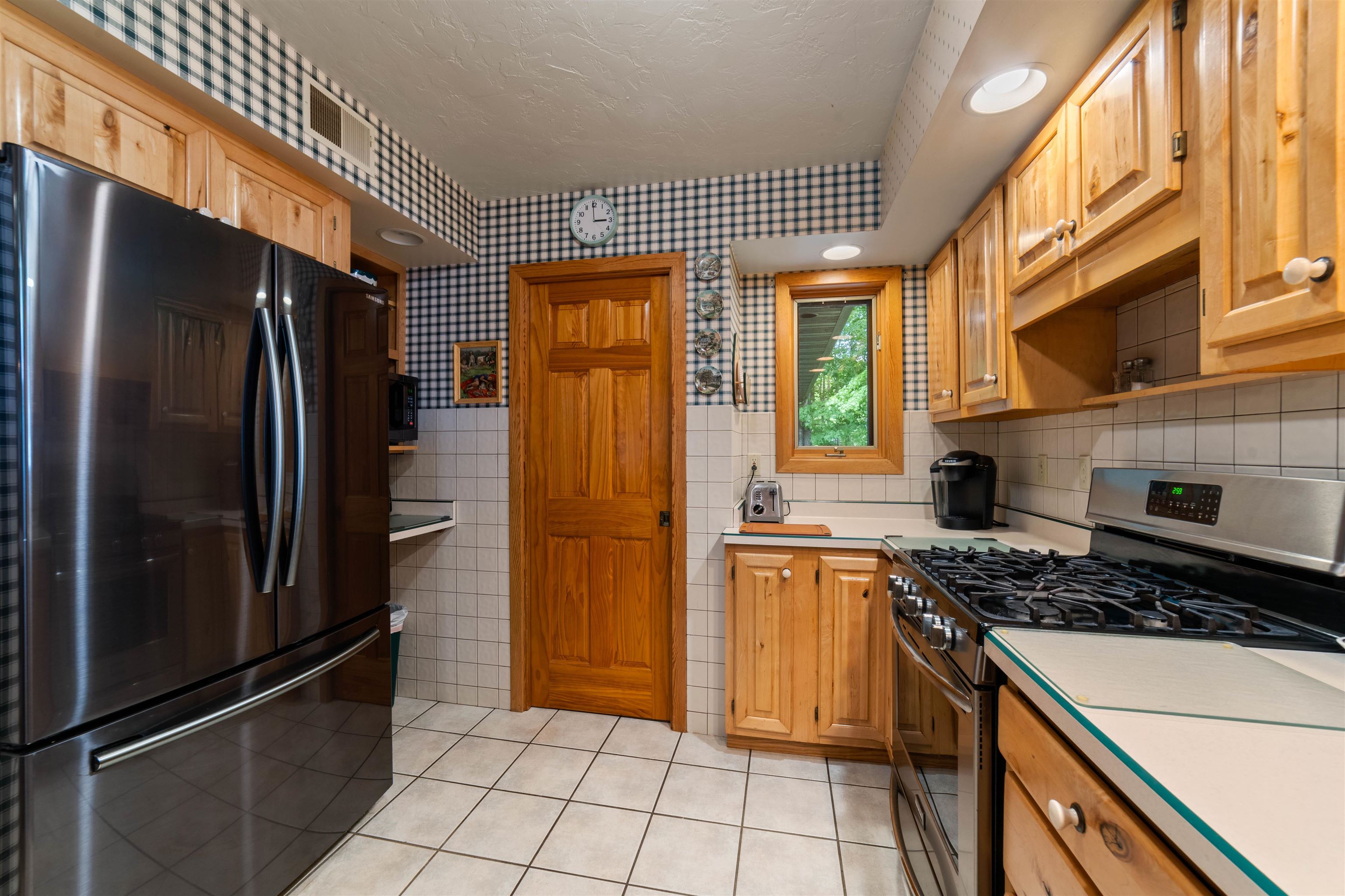 4930 Mini Power Road Duluth, MN 55803 - Photo 9 of 36 Kitchen featuring freestanding refrigerator, stainless steel range with gas stovetop, light countertops, light tile patterned floors, and open shelves